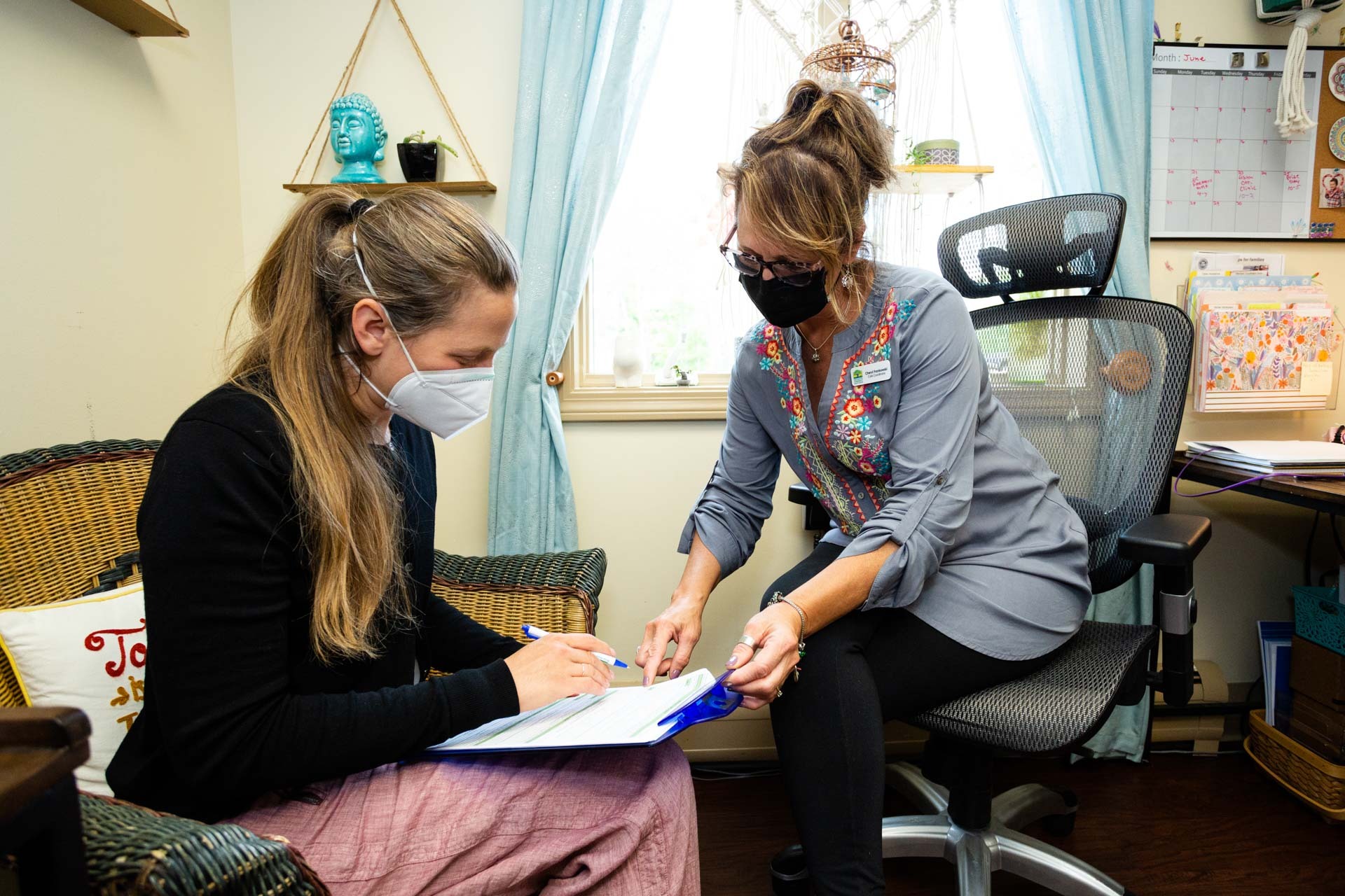 Female medical professional reviewing paperwork with female client