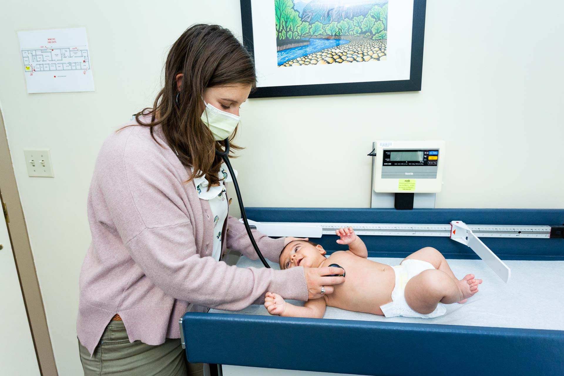 Medical professional listens to baby's chest with stethoscope