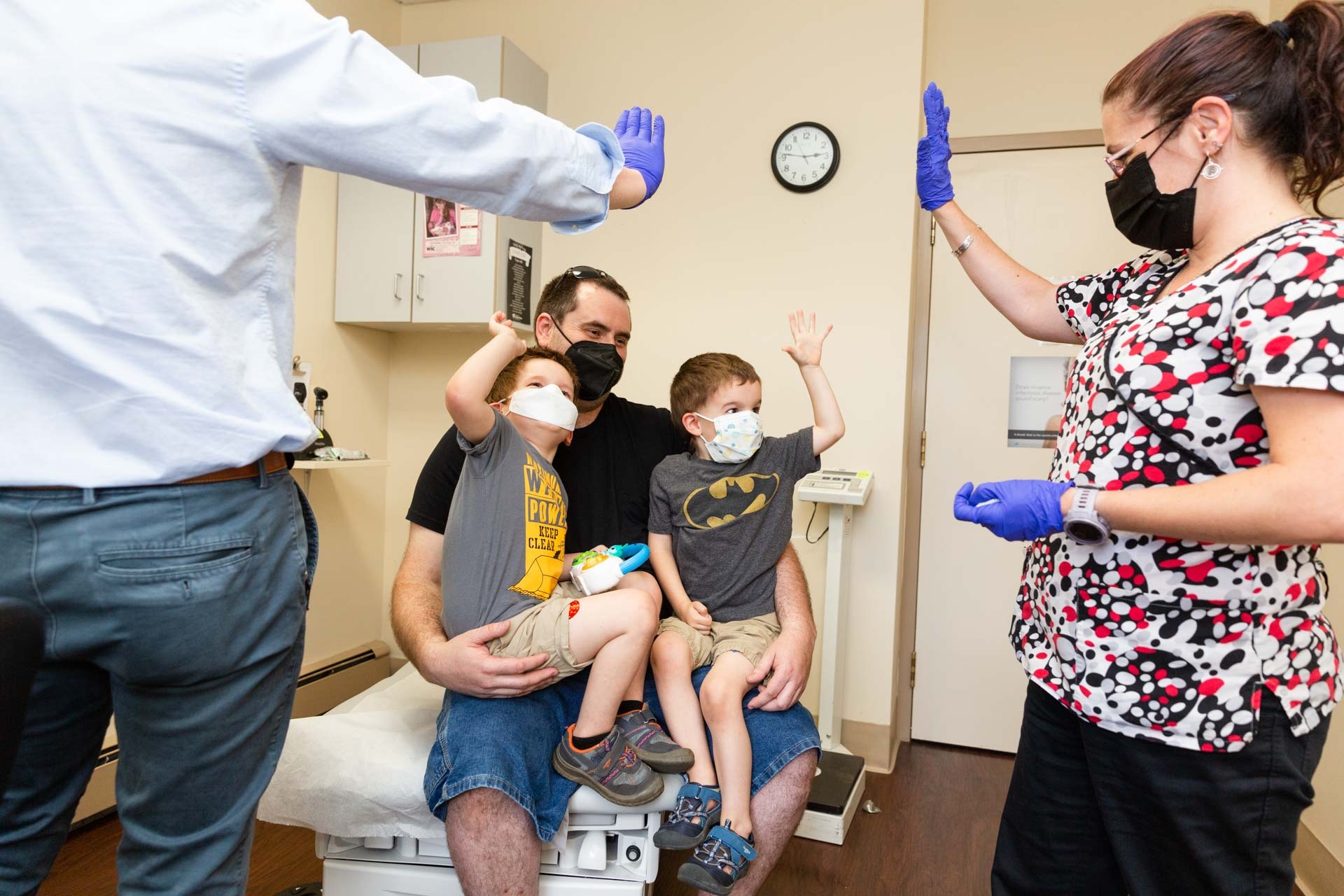 High fives from medical professionals to young patients